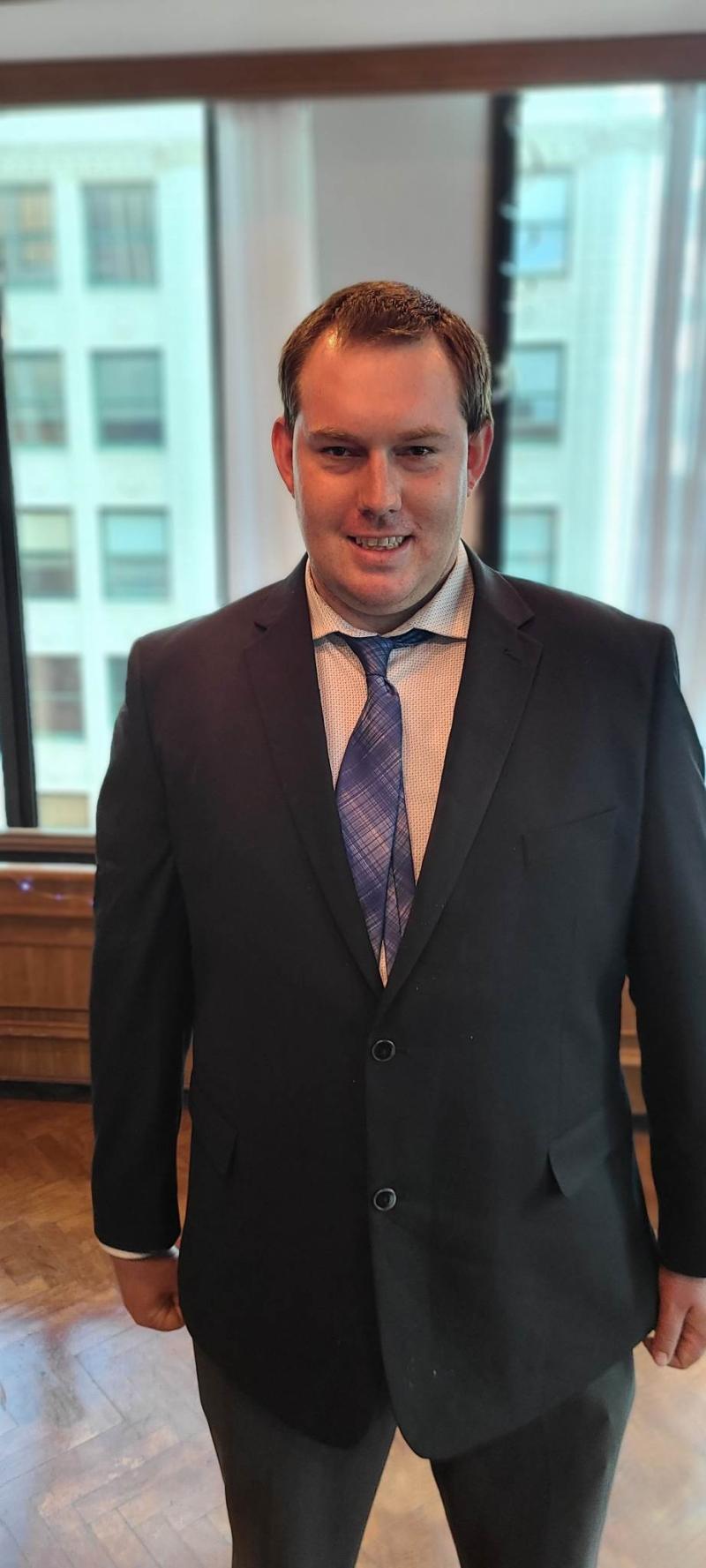 a man in a suit and tie smiles for the camera