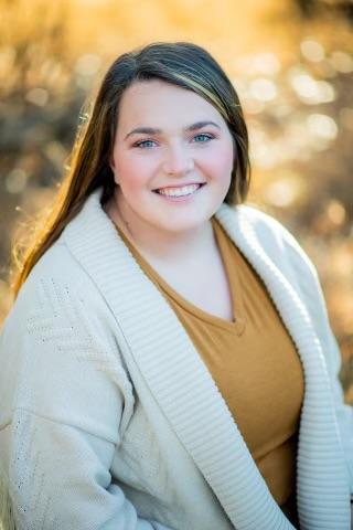 A woman with long brown hair smiles at the camera