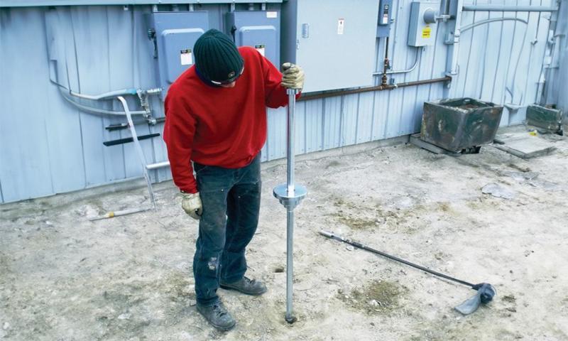 Man using a dynamic cone penetrometer.
