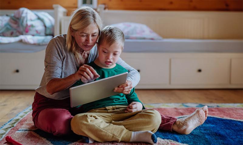 Grandmother and grandchild using a tablet.