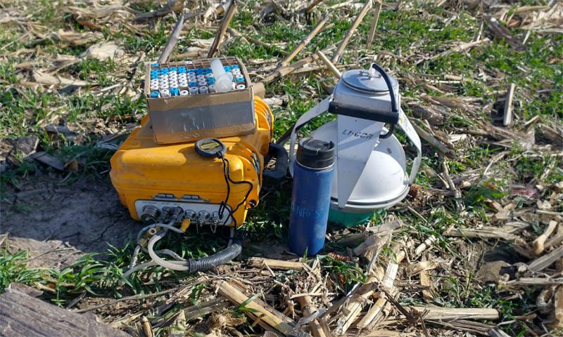 Equipment used to measure soil gas emissions resting in a field.