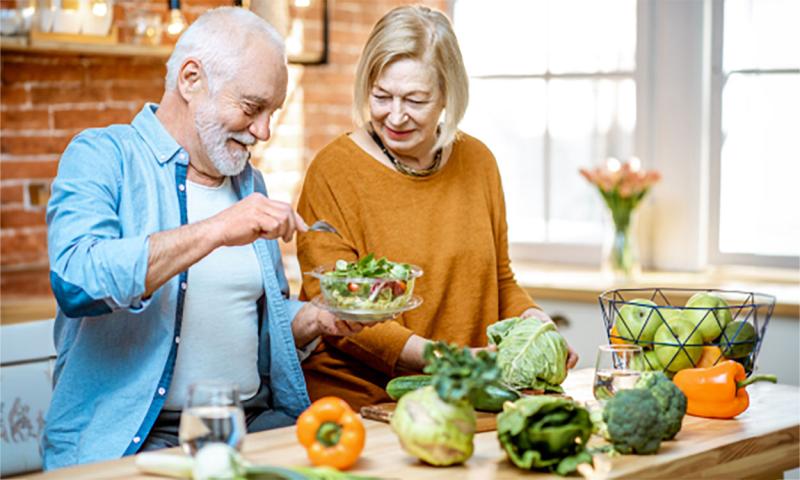 Husband and wife preparing a healthy meal.