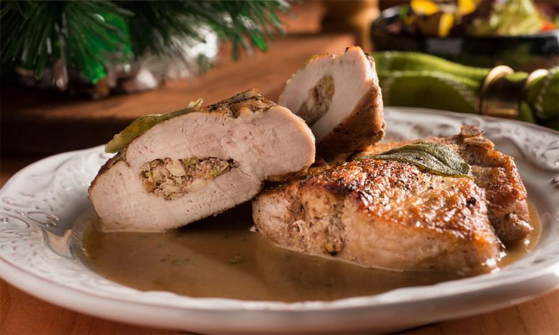 Stuffed porkchop with gravy on a holiday table setting.