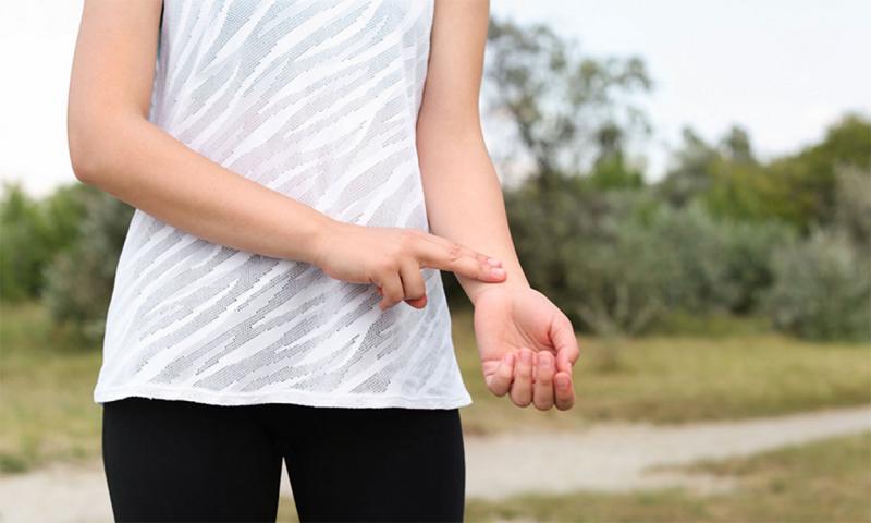 Young woman checking her pulse using the radial pulse method.