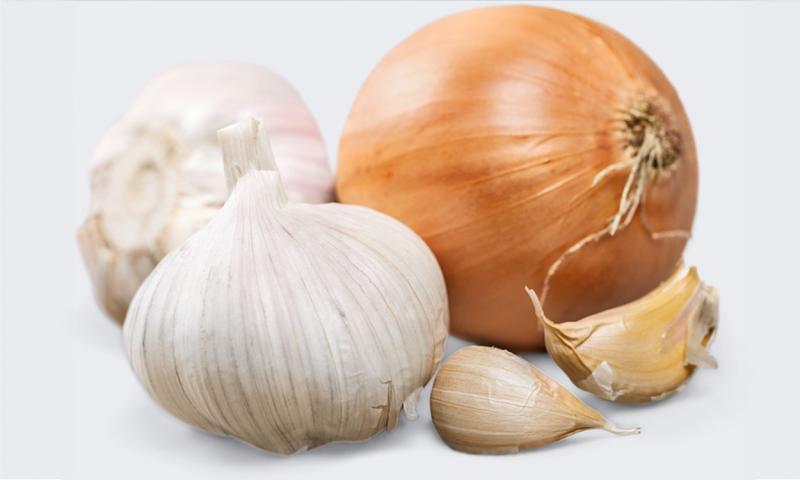 Two cloves of garlic and a yellow onion.