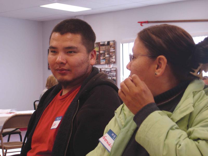 A man looks forward and a woman next to him looks at him