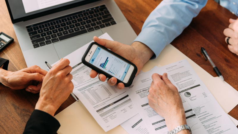 Three people looking at financial documents
