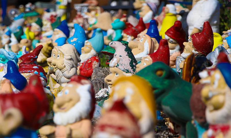 Large collection of lawn ornaments hoarded in a yard.