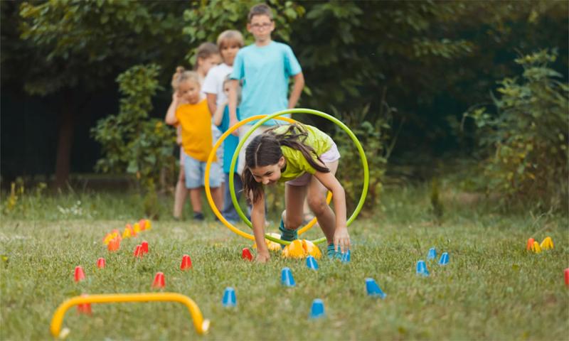 Group of kids racing through an obstacle course in their backyard.