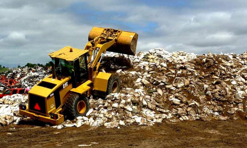 Excavators moving sandbags and flood debris in Pierre, South Dakota.