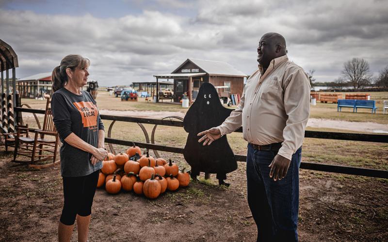 Agritourism proprietor and a local official meeting at a pumpkin patch.