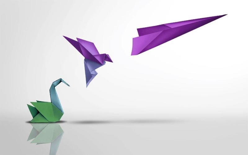 A resting paper bird, followed by a paper bird in flight, followed by a paper airplane, symbolizing transformational leadership style.
