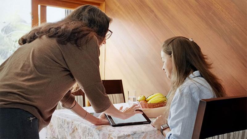 In-home dietician and client viewing information on a tablet computer.