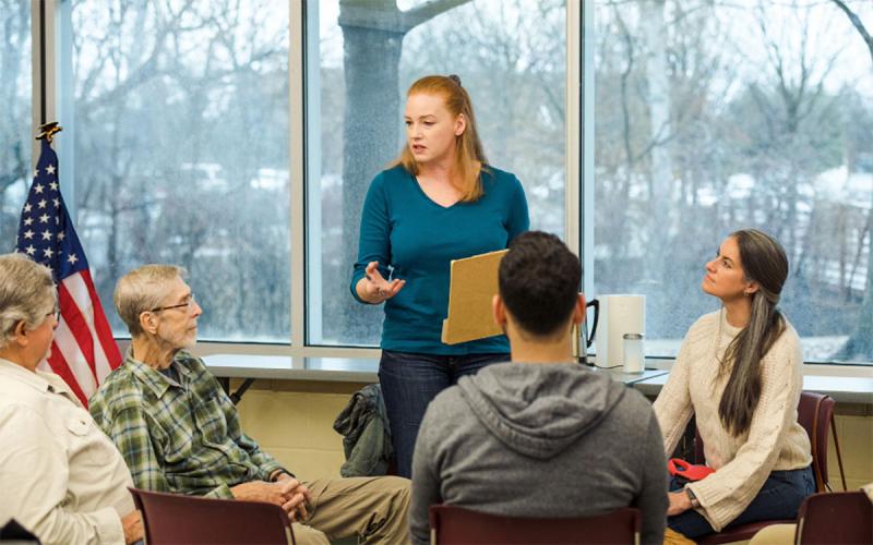 Community leader engaging with a small group of constituents at a community center.