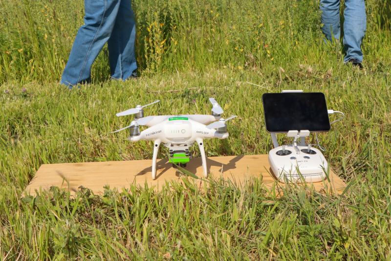 A drone used for precision agriculture sits on a piece of wood