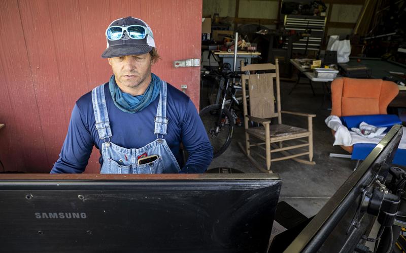 Famer reviewing information on a computer screen in a workshop.