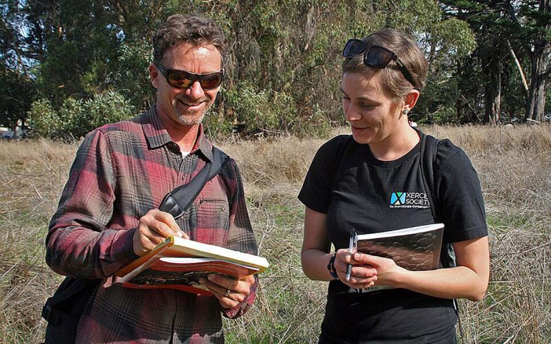 A conservation biologist and Xerces Society member examining resources in a field.