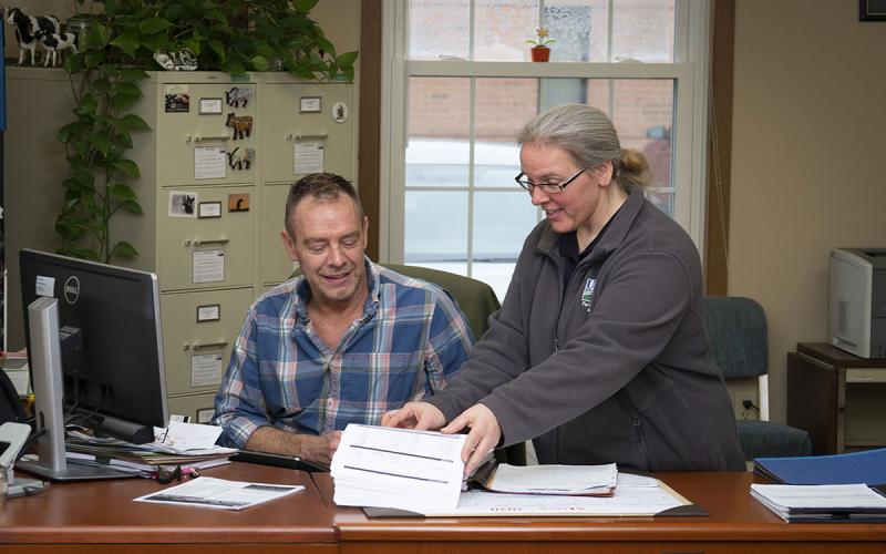 Rancher meeting with a USDA agent in a service center office.