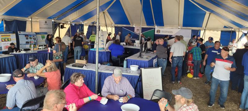 People eat ice cream under a large tent