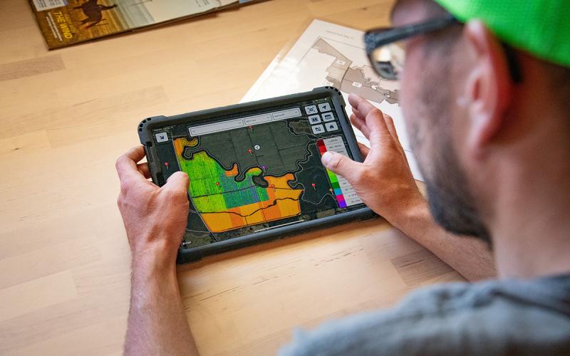 Farmer viewing precision seed application data on a tablet.