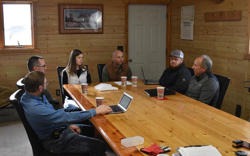 Group of producers and ag experts gathered around a table.