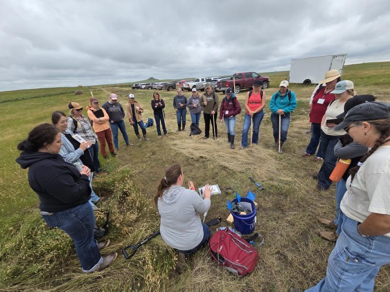 Women standing in a circle learning about rangeland plants