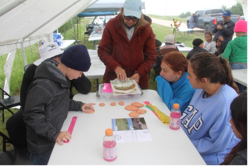 A woman works with youth at a table