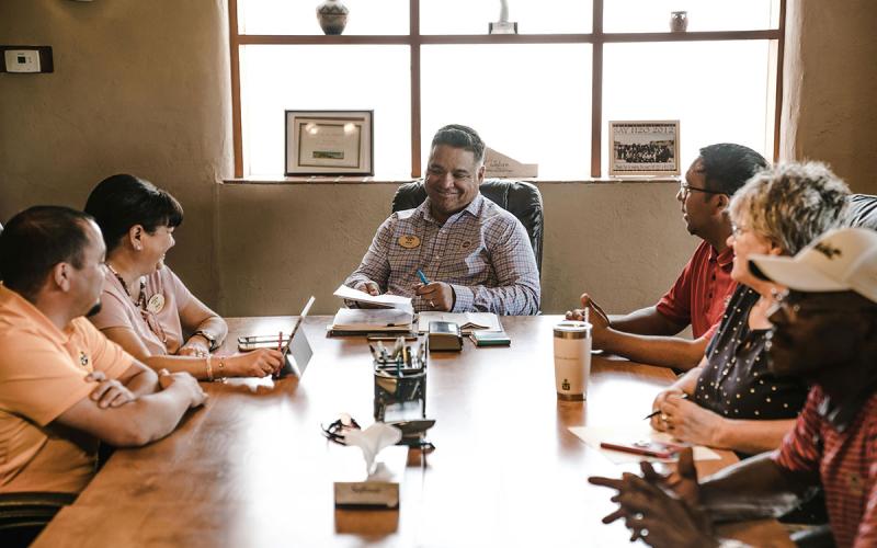 Group of people gathered around a table in an office.