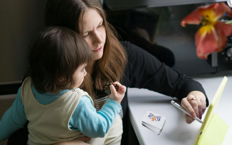 Mother and toddler doing a learning activity on a tablet computer.