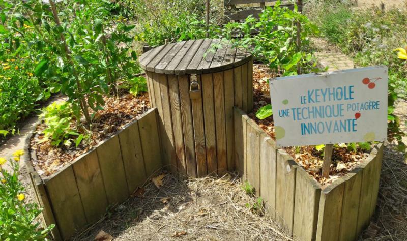 Wooden planks forming a raised circular garden bed with a notch in the side for access