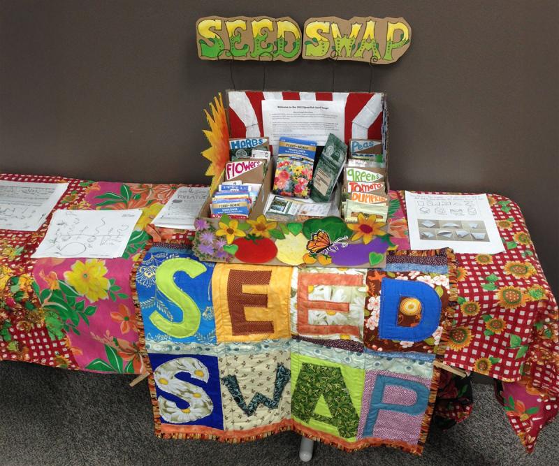 A decorated seed swap table with a seed collection on display along with activity sheets.