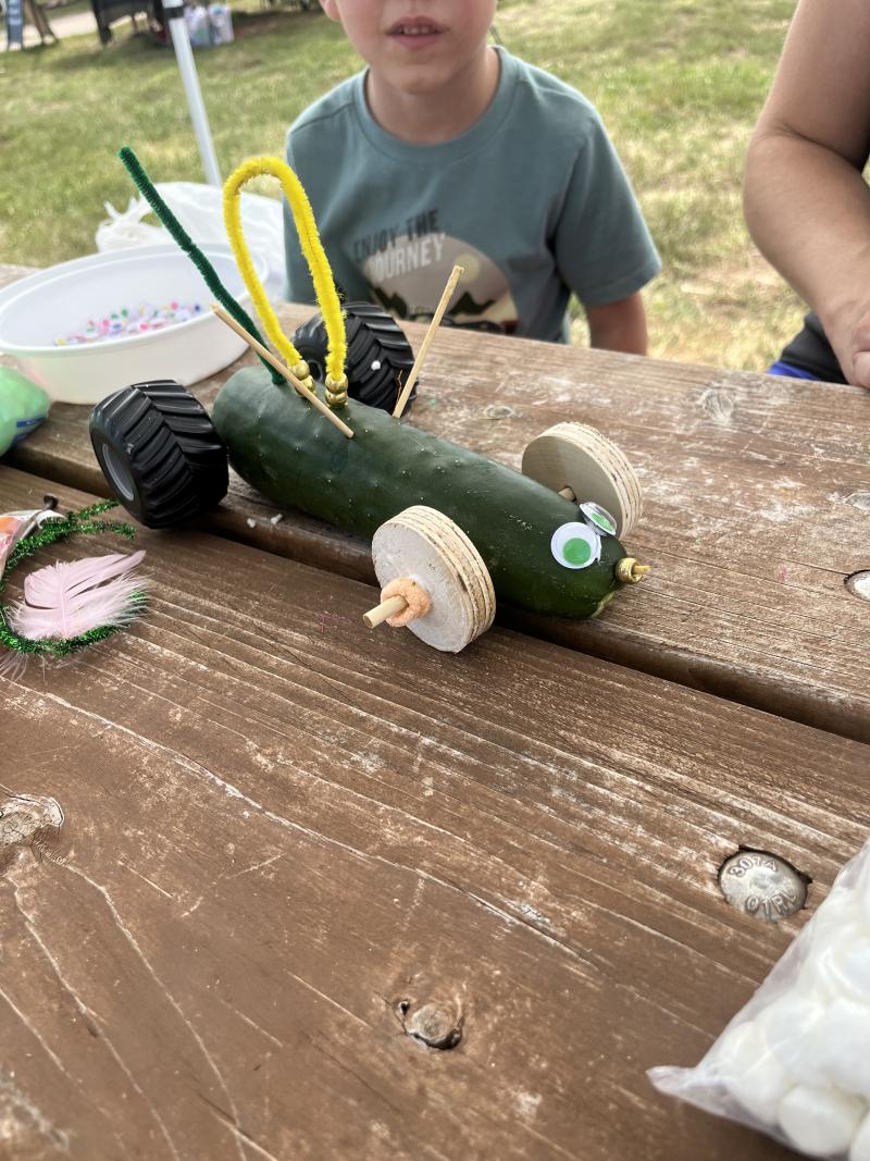 A zucchini with wheels and decorations