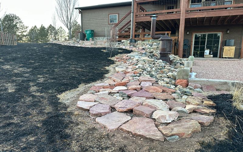 Home landscape surrounded by rocks and gravel in the immediate home ignition zone.