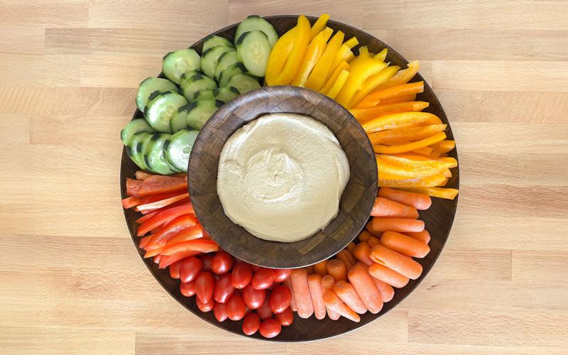 Variety of fresh cut vegetables and dip arranged on a platter.