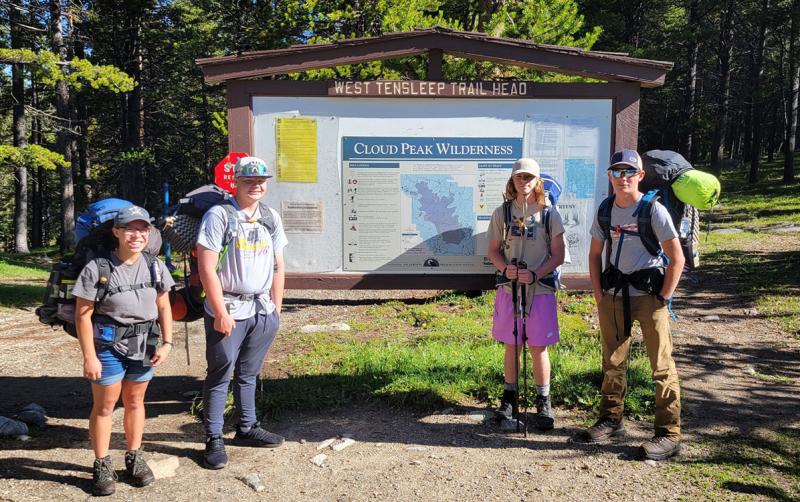 Group of children at the trailhead of a hiking trail.