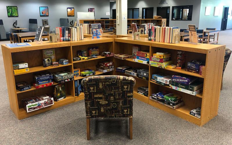 A library nook with two shelves dedicated to games, puzzles, and things.