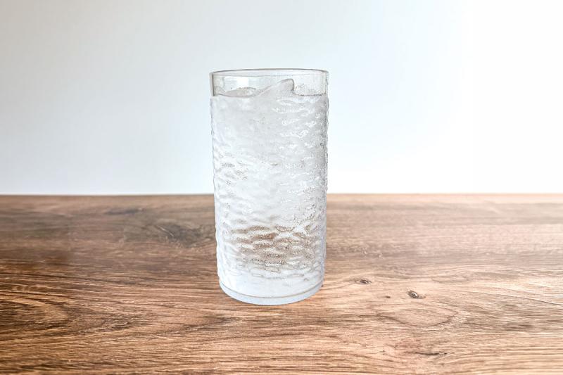 Glass of water sitting on a hardwood table.