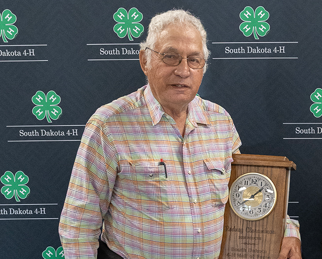 2026 4-H Volunteer Hall of Fame Honoree, Rodney Clarambeau, standing in front of a backdrop with his award.