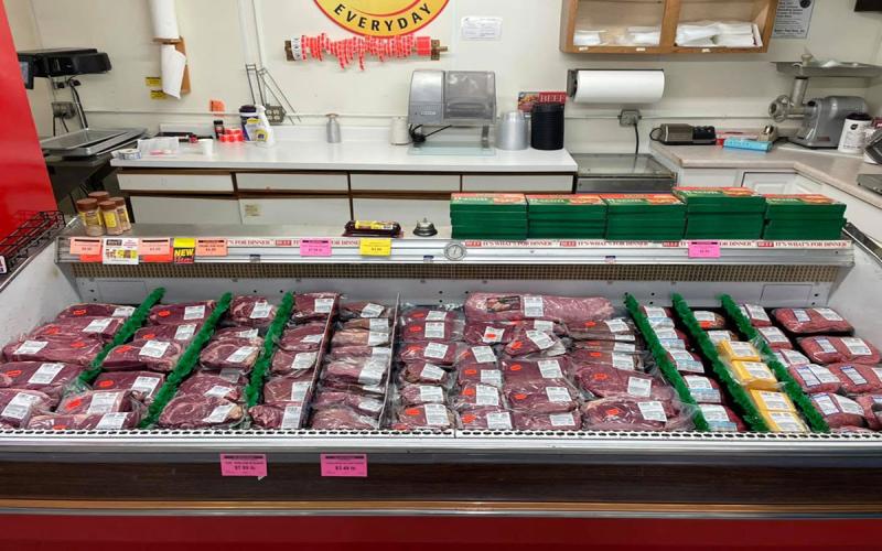 Meat counter with a variety of products on display at a small-town grocery store.