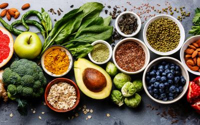 a variety of bright colored fruits and vegetables arranged on a table