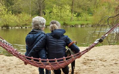 two people sitting on a rope swing