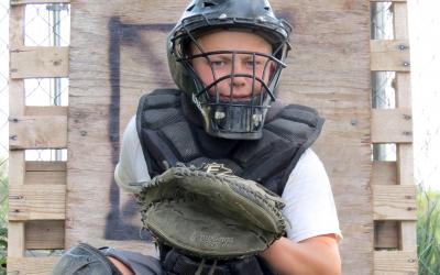 male youth dressed in baseball catcher's equipment