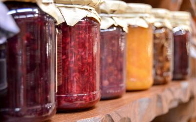cans of various jams and jellies on a shelf