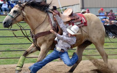male youth running with a sandy-brown horse