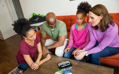 family gathered around an emergency weather radio