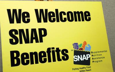 Sign at a farmers market reading "we welcome SNAP benefits"