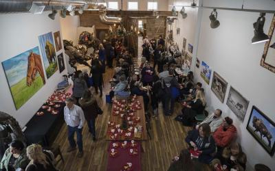 A crowd of Energize Conference attendees enjoying refreshments served in a local art gallery.