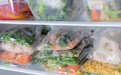 Freezer meals Plastic bags and containers with frozen vegetables in refrigerator