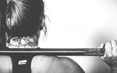 A young woman lifting weights.