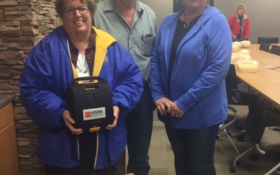 an image of two women and a man with a donated automated external defibrillator